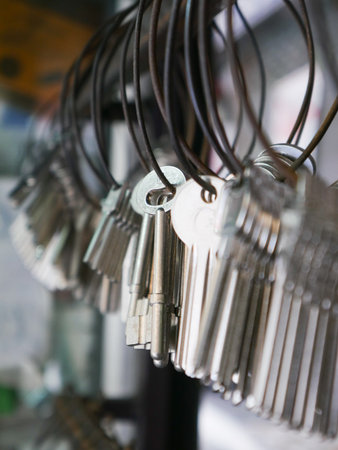Multiple Duplicate Keys Hanging on Wire Rings at Locksmith Shop - Key Cutting and Duplication Service Businessの写真素材