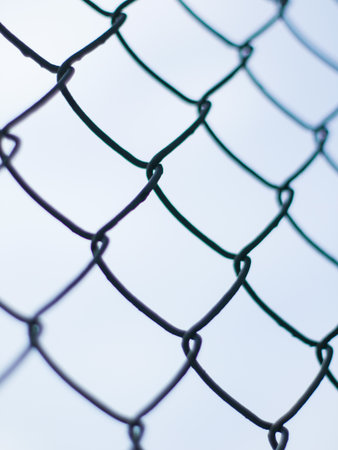 Abstract Chain Link Fence Pattern with Selective Focus - Minimalist Wire Mesh Texture with Soft Bokeh Backgroundの写真素材