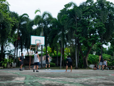 Blurred Basketball Court with Group of People Playing Game Outdoors.の写真素材