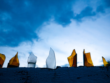 Broken Glass Bottles Embedded in Concrete Wall Against Blue Sky