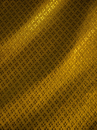 Abstract Golden Mesh Fabric Texture with Flowing Folds - Luxurious Shimmering Material Backgroundの写真素材