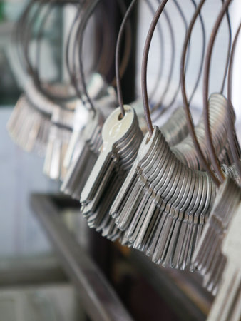 Multiple Duplicate Keys Hanging on Wire Rings at Locksmith Shop - Key Cutting and Duplication Service Businessの写真素材