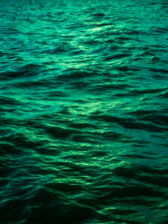 Turquoise Green Ocean Water Waves Surface with Golden Light Reflection - Tropical Sea Texture Background Patternの写真素材