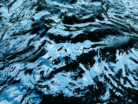 Dark Blue Water Surface with Ripples and Reflections - Abstract Liquid Texture Backgroundの写真素材