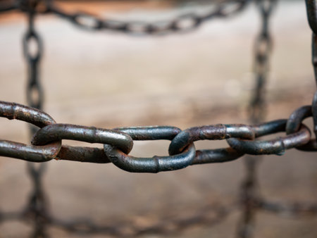 Close up of old rusty metal chain links with corrosion and weathered surface texture showing age and...