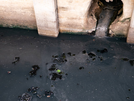 Contaminated Sewage Water Discharge Through Weathered Tunnel Opening in Urban Waterwayの写真素材