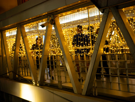 Modern Bridge Walkway with Golden String Lights: Urban Architecture Night View with Festive...