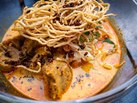 Khao Soi Beef Close-up: Northern Thai Curry Noodle Soup Braised Beef Crispy Fried Noodles Coconut...