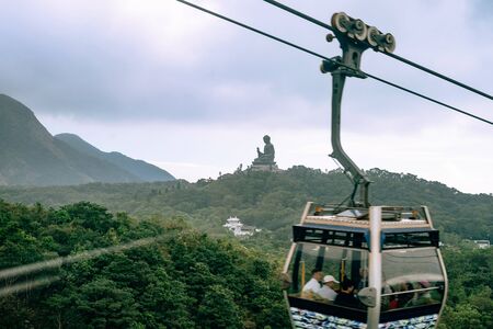 Famous Tian Tan Buddha with Cableway passing in frontの写真素材