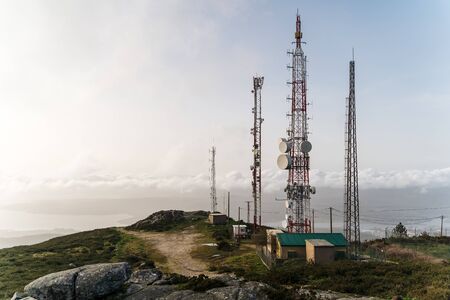 Communication Antennas on top of mountain with view of city in northern spain at sunset