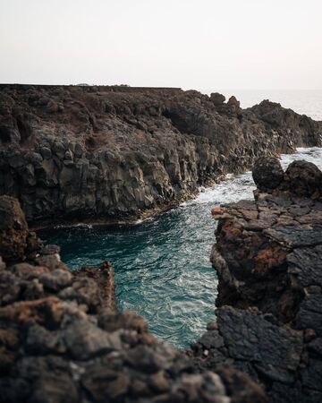 Natural rocky formations with the ocean entering in Los Hervideros, Lanzarote, Spainの写真素材
