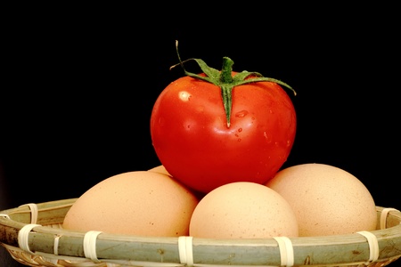 easter preparation - unpainted eggs in a trellis basket on dark backgroundの写真素材