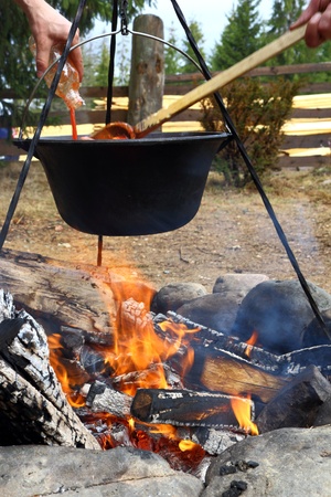 outdoor cooking in cauldron over the fireの写真素材