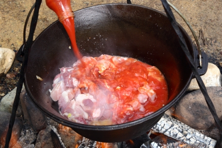 preparing osso buco outdoor in traditional cauldronの写真素材