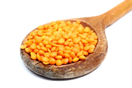 bunch of red lentil in wooden spoon over whiteの写真素材
