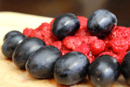 arrangement of wild crushed raspberry and red grapes の写真素材