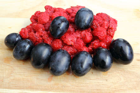 wild raspberry from the freezer and red grapesの写真素材
