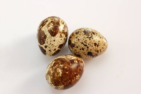 three quail eggs over gray backgroundの写真素材