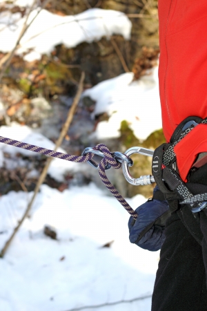 climber holding the rope with gloves in winterの写真素材