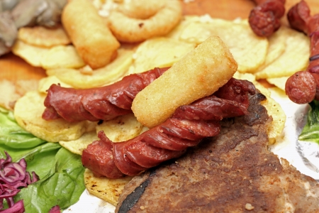 sausages and potatoes served with green salad and some baked cheeseの写真素材