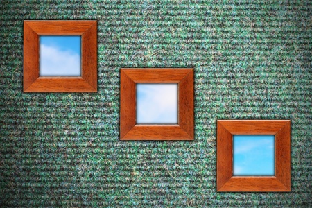 grungy wall with carpet texture and three wooden frames with blue sky の写真素材