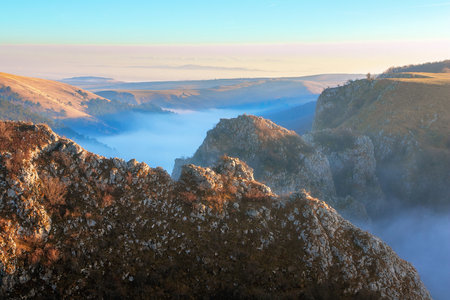 mist over limestone ridge in Tureni gorges, a protected area in Transylvaniaの写真素材
