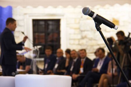 Investment Forum: microphone on the background of a businessman who speaks to the audience on stage.の写真素材