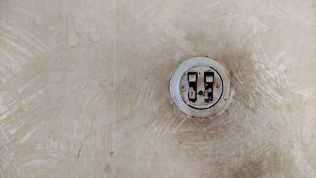 Soviet electrical switch on a dirty wall. Vintage background in grunge style.