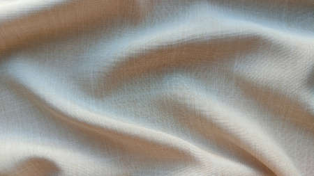 Canvas beige fabric background with waves close, interesting wavy background, top view waves on fabric, soft wrinkled matte fabric, shadow fabricの写真素材
