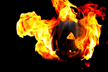 Halloween pumpkin is spewing fire flame flow on a black background is very impressive and colorfulの写真素材