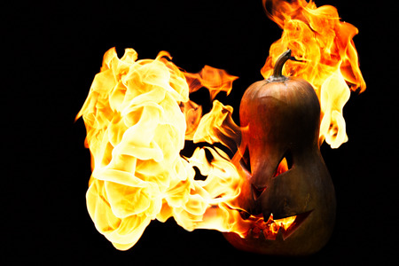 scary Halloween pumpkin is spewing fire flame isolated on black backgroundの写真素材