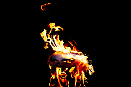 Halloween pumpkin is spewing fire flame flow on a black background is very impressive and colorfulの写真素材