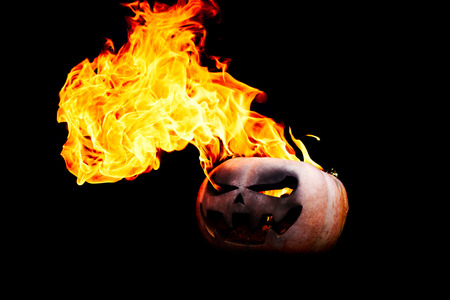 Halloween pumpkin is spewing fire flame flow on a black background is very impressive and colorfulの写真素材