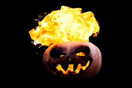 Halloween pumpkin is spewing fire flame flow on a black background is very impressive and colorfulの写真素材