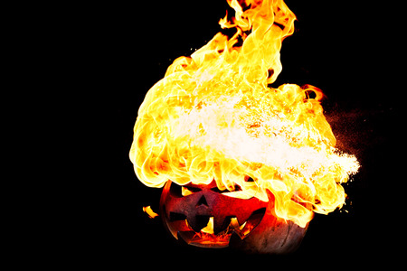 Halloween pumpkin is spewing fire flame flow on a black background is very impressive and colorfulの写真素材