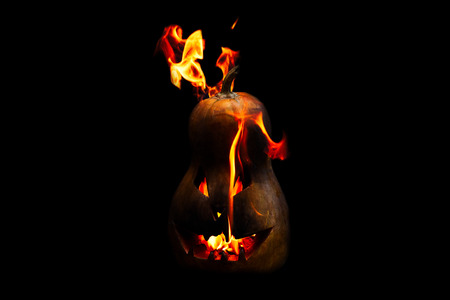 scary Halloween pumpkin is spewing fire flame isolated on black backgroundの写真素材