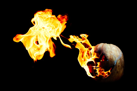Halloween pumpkin is spewing fire flame flow on a black background is very impressive and colorfulの写真素材