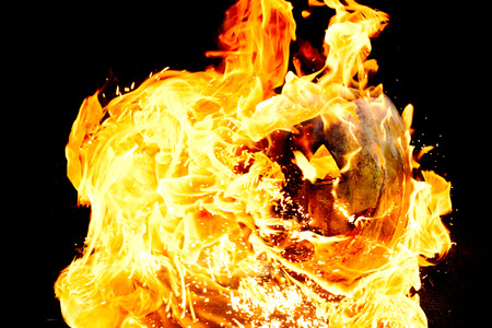 Halloween pumpkin is spewing fire flame flow on a black background is very impressive and colorful
