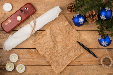 Christmas background with sheet of parchment with a pen, clock, fir branches, pine cones on old...
