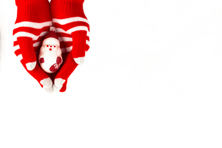 Christmas card, gloves on hands holding santa claus isolated on a white background with space for textの写真素材