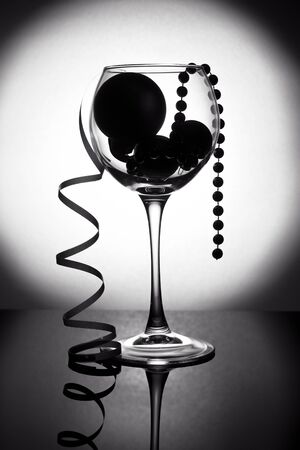 Christmas card, wineglass with balls with gradient and space for textの写真素材