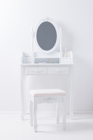 portrait of vintage vanity table mirror set with stool and accessories on white wallの写真素材