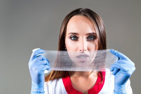 woman doctor, nurse, close up, holding a bandage in the face, with space for text