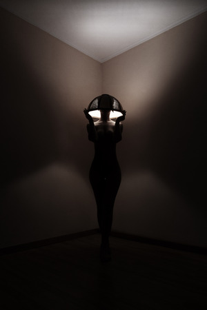 naked girl topless with a lampshade on her headの写真素材