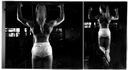 Fitness young sweaty girl with a sports body in the gym doing exercises for back pulling up on a...