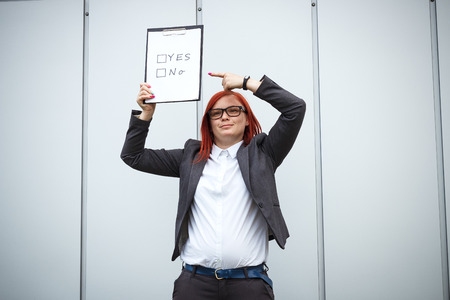 Business concept of choice and voting. A woman in a suit and glasses makes a yes or no choice. With a place for advertising text. Chef Day, Boss Day, Electionsの写真素材