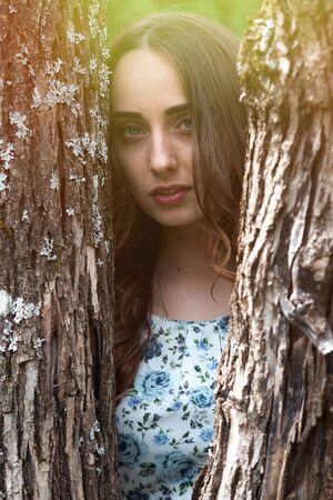 Woman or girl in a dress standing in a parkの写真素材