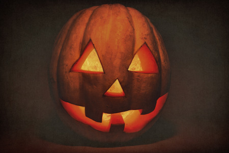 Very kind and funny Halloween pumpkin, with a funny look and a snobbish smile, in the darkの写真素材