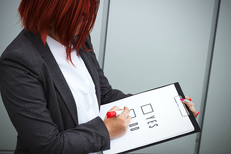 Business concept of choice and voting. A woman in a suit and glasses makes a yes or no choice. With a place for advertising text. Chef Day, Boss Day, Electionsの写真素材