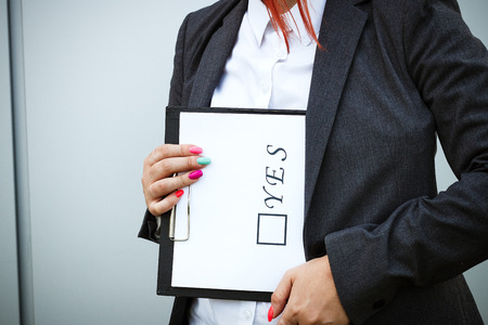 Business concept of choice and voting. A woman in a suit and glasses makes a choice - yes. With a place for advertising text. Chef Day, Boss Day, Electionsの写真素材